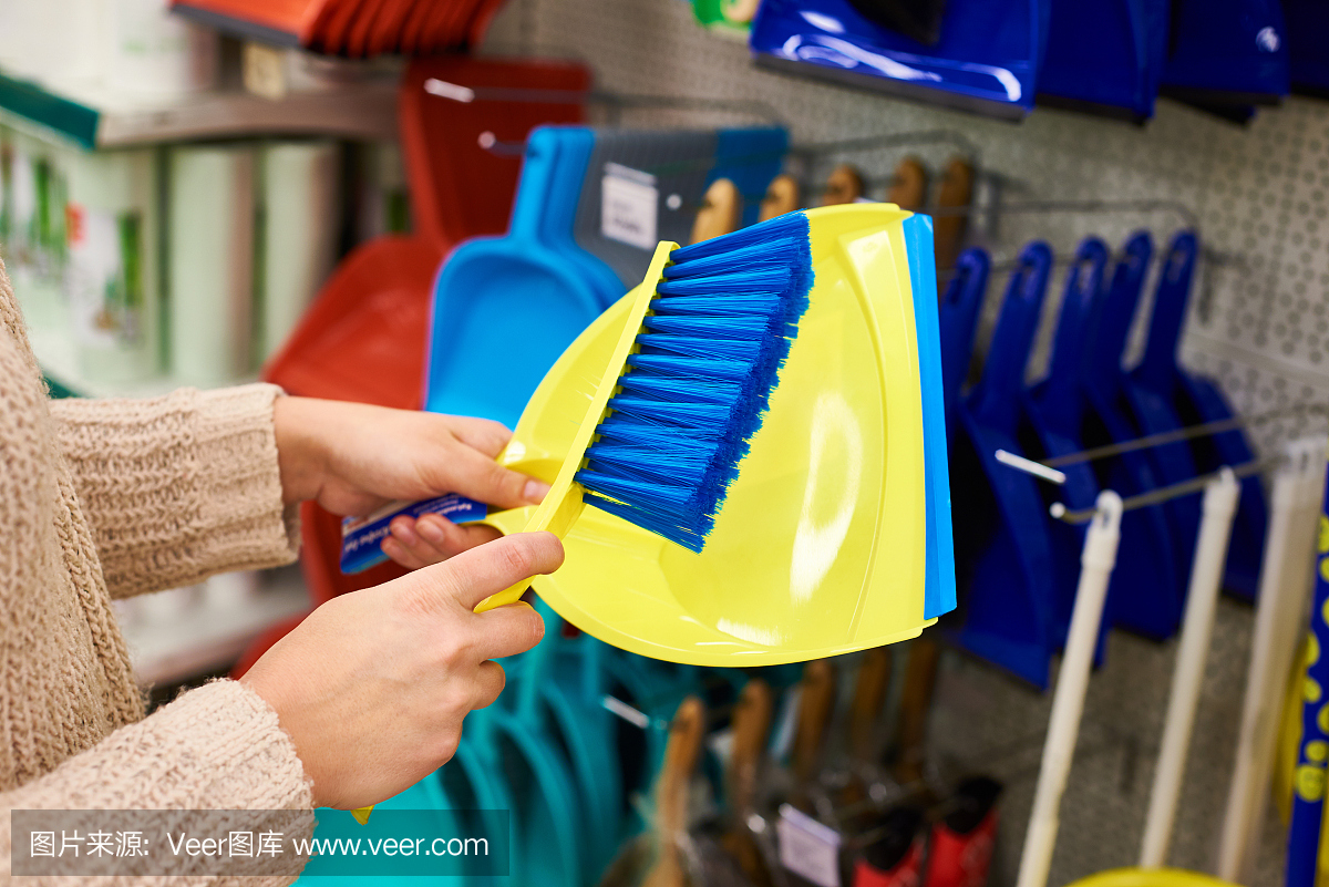 女人的手和清潔刷和勺子在商店